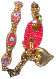 two gold and pink bracelets with evil eyes on them, one has a bell