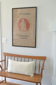 a wooden bench sitting in front of a wall with a poster on it's side