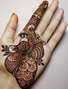 the hand is decorated with henna designs on it's palm, and has an intricate