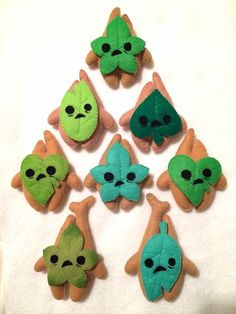 a bunch of small green and brown items on a white surface with one being an alien