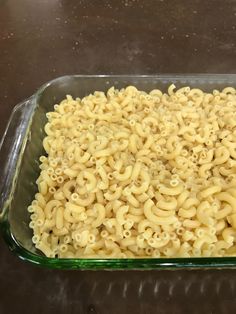 a glass casserole dish filled with macaroni and cheese on a table