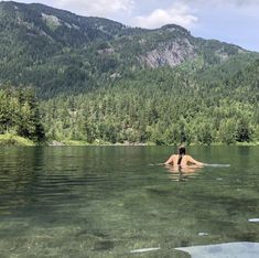 a woman is floating in the water with her back turned