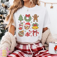 Get into the festive spirit with this Bella Canvas Christmas Icons shirt!  Featuring a charming collection of holiday-themed images, including a snowman, garland, ornament, Christmas tree, and more, this shirt is the perfect way to showcase your love for the season.  Whether you're wearing it to a holiday party or just embracing the Christmas cheer at home, this soft and comfortable tee is ideal for both men and women. Crafted from high-quality Bella Canvas material, it's designed for lasting co Sublimation Christmas Shirts, White Festive Christmas Shirt, White Festive Shirt For Christmas, Snowman Garland, Ornament Christmas Tree, Christmas Graphic, Sublimation Christmas, Christmas Icons, Holiday Wear