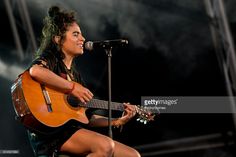 a woman playing an acoustic guitar on stage