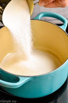 a person pouring sugar into a pan on the stove