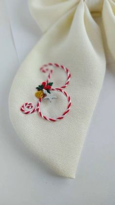 a close up of a tie with candy canes on it and an ornament