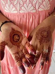 two hands with henna tattoos on them