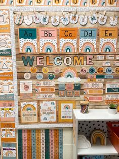 a welcome sign is displayed on a wall with many different colors and patterns in the background