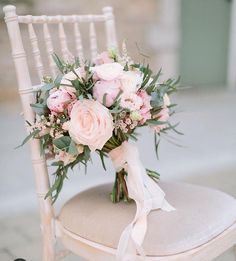 a bouquet of pink flowers sitting on top of a chair