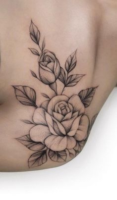 a black and white rose tattoo on the side of a woman's stomach, with leaves