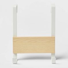 a white and wood shelf with two legs on it's sides, against a white background