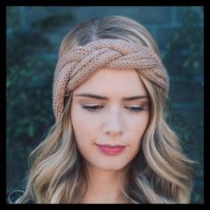 a woman with blonde hair wearing a knitted headband and looking down at the camera