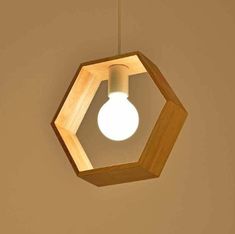 a wooden light fixture hanging from the ceiling with a white light bulb in it's center