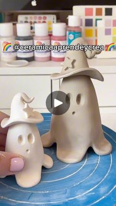 a person is holding a fake ghost with a hat on it's head and another toy in front of them