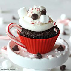 a cupcake with marshmallows and chocolate chips on top is sitting on a plate