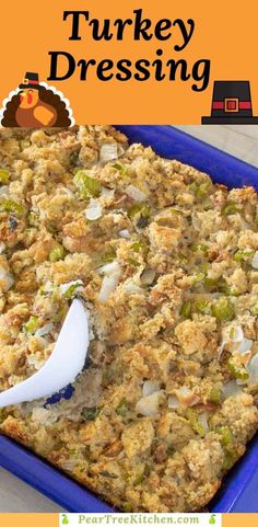 a blue casserole dish filled with turkey and stuffing, topped with a white serving spoon