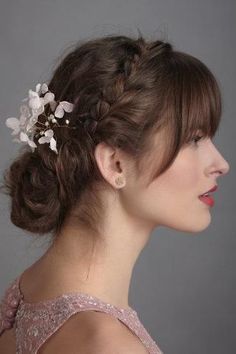 a woman with a flower in her hair is wearing a pink dress and looking off to the side