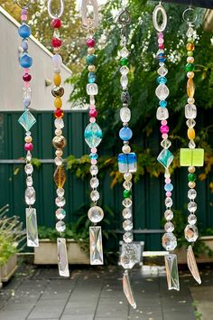 a wind chime hanging from the side of a building with lots of beads on it