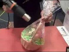 a person pouring something into a bag on top of a red table with a wine bottle in the background