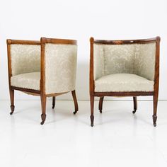 two chairs sitting next to each other on a white floor