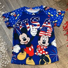 Adorable Gender Neutral Blue And Red Minnie & Mickey Patriotic Designed Short Sleeve T-Shirt With Blue Stars And Small Characters On Back. Playful T-shirt For 4th Of July With Crew Neck, Playful Crew Neck T-shirt For 4th Of July, Blue Family Matching Short Sleeve Tops, Red Cartoon Print Tops For Playwear, Playful Summer Tops With Mickey Mouse, Playful Mickey Mouse Tops For Summer, Blue Family Matching T-shirt With Cartoon Print, Fun Blue T-shirt For 4th Of July, Family Matching Blue T-shirt With Cartoon Print