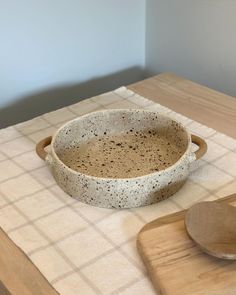 a wooden spoon sitting on top of a table next to a bowl