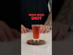 a man sitting at a table with a drink in front of him and the words woo woo shot on it