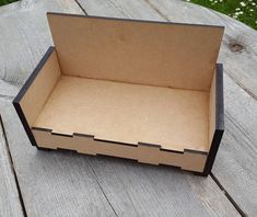 an open cardboard box sitting on top of a wooden table with grass in the background