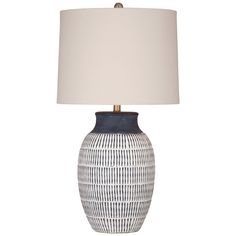 a white and blue lamp with a beige shade on the top is sitting in front of a white background