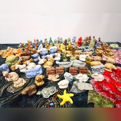 a table topped with lots of small figurines on top of a black surface