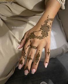 a woman's hand with henna tattoos on it