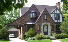 a large brick house sitting on top of a lush green field