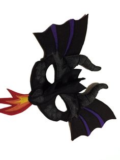 a black and purple dragon mask with flames coming out of it's mouth, on a white background