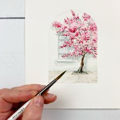 someone is painting a tree with watercolors on paper