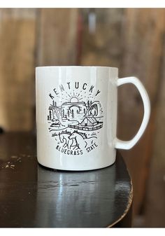 a white coffee mug sitting on top of a wooden table