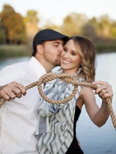 a man and woman standing next to each other with a rope in front of them