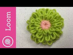 a crochet flower with pink center on top of white fabric and text that reads,