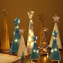 small christmas trees with lights on them sitting on a table