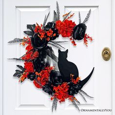 a white door with a black cat and red flowers on it