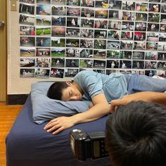 a man laying on top of a bed next to a camera