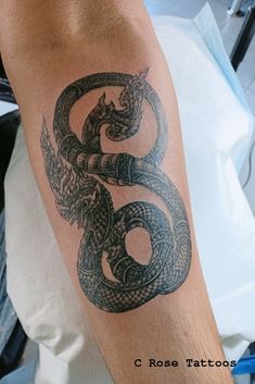 a man's arm with a tattoo on it that has a snake in the middle