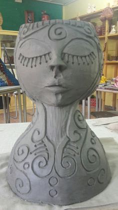 a clay sculpture of a woman's head on a table