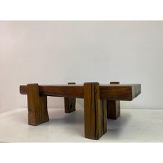 two wooden benches sitting next to each other on a white surface with one bench made out of wood