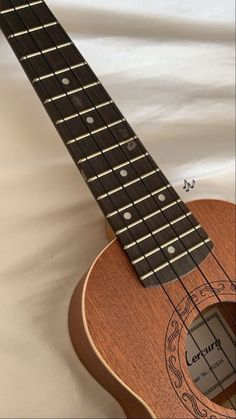 the ukulele is made from wood and has an intricate design on its neck