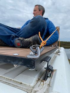 a man sitting on top of a boat in the water