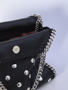 This black vegan fabric Falabella mini tote bag is adorned with all-over studs. It boasts a silver-tone diamond-cut chain, two top handles, one shoulder strap, magnetic closure, and one main interior compartment with an additional slip pocket.    Dimensions: 10x9.2x3.9 inches   Vegan fabric  All over studs  Two top handles  Magnetic closure  Slip pocket  Product code: 371223WP04541000  Composition: 51% polyester, 49% polyurethane Chic Studded Shoulder Bag, Chic Studded Crossbody Shoulder Bag, Chic Studded Shoulder Bag For Party, Studded Leather Party Bag, Leather Party Bag With Studs, Party Leather Shoulder Bag With Rivets, Chic Party Shoulder Bag With Studs, Leather Party Shoulder Bag With Rivets, Leather Shoulder Bag With Rivets For Party