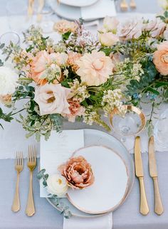 the table is set with flowers and silverware