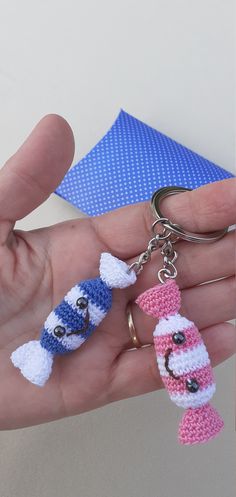 a hand holding two crocheted keychains in each other's palm