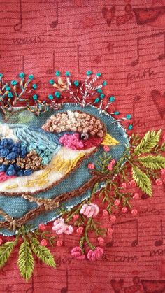 a close up of a bird on a blue plate with flowers and leaves around it