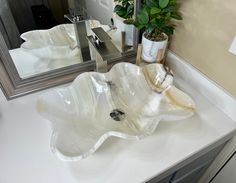 a white sink sitting on top of a counter next to a mirror